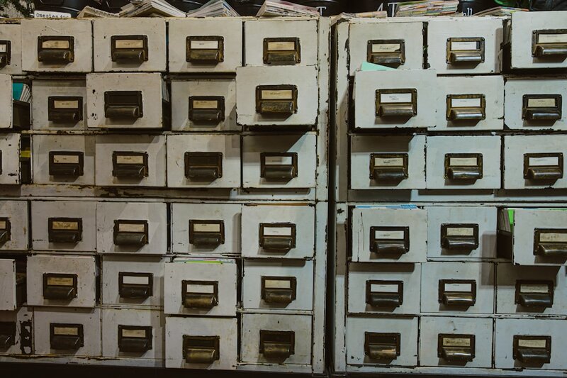 Rows of old labelled filing cabinet drawers, representing permanent metadata records