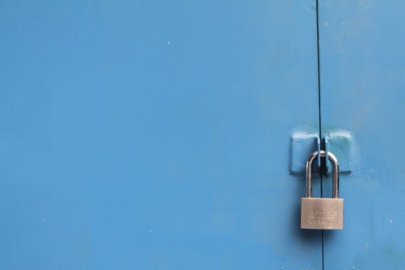 A silver padlock on a door, representing an identity provider as the single lock protecting every downstream service