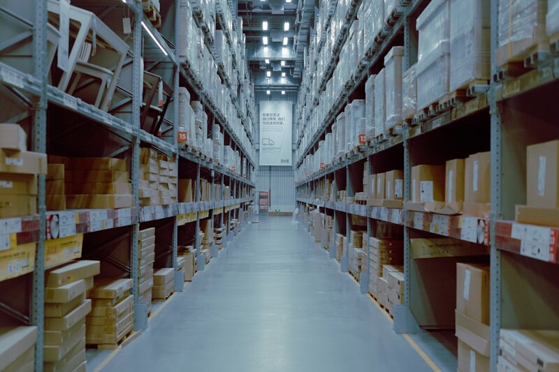 Rows of identical warehouse shelving stacked with indistinguishable boxes, representing seven separately versioned plugin editions shipping under one identifier