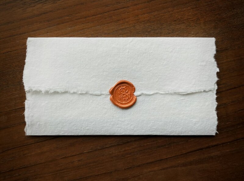 A red wax seal stamped onto a sheet of paper