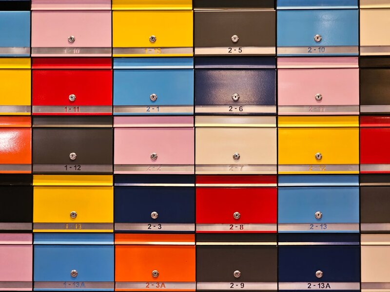 A grid of numbered letterboxes in many colours mounted on a wall