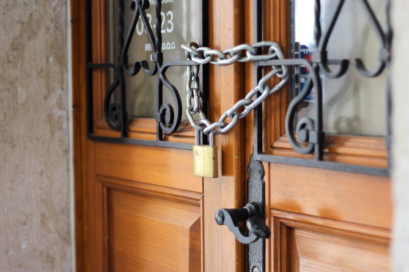 A padlocked chain fastened across a pair of wooden doors