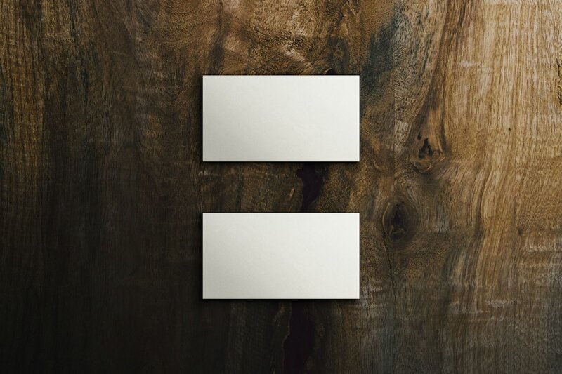 Two blank white name cards pinned to a dark wooden surface
