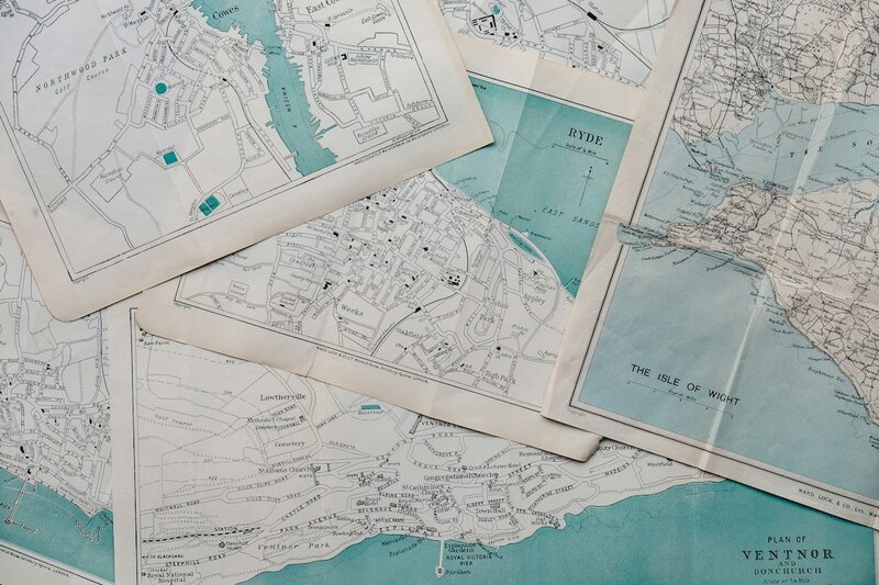 Several overlapping printed maps of the same coastline, each drawn to a different scale