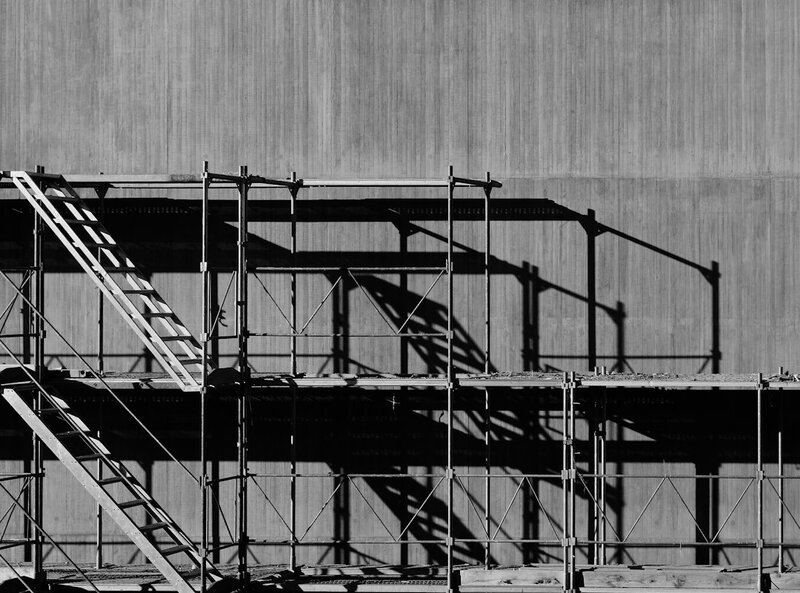 Scaffolding still standing against a finished concrete wall