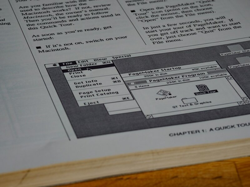 A printed software manual open at a step by step quick tour chapter