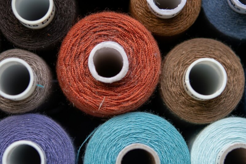 Spools of thread in different colours, viewed from above