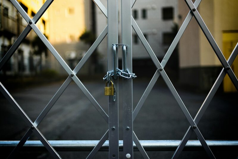 A steel gate closed with a padlock and chain